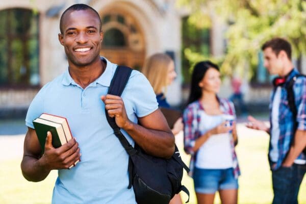 A man holding books and smiling for the camera.